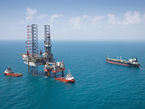 Image of oil platform while cloudless day. Oil platform on sea is offshore structure with facilities to drill wells, extract and process oil and natural gas and temporarily store produced goods until it can be brought to the shore for refining.
